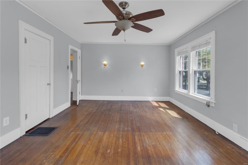 Spare room with crown molding, visible vents, ceiling fan, and hardwood / wood-style floors