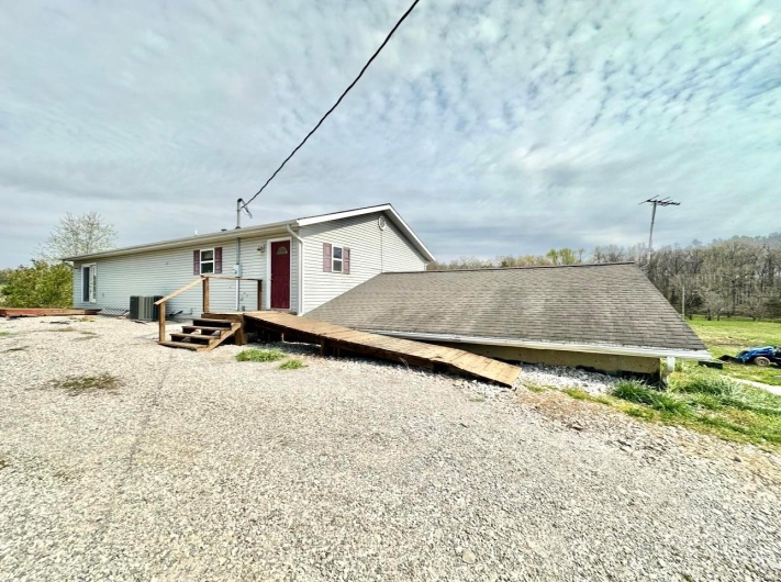 View of front of house featuring a wooden deck and central air condition unit