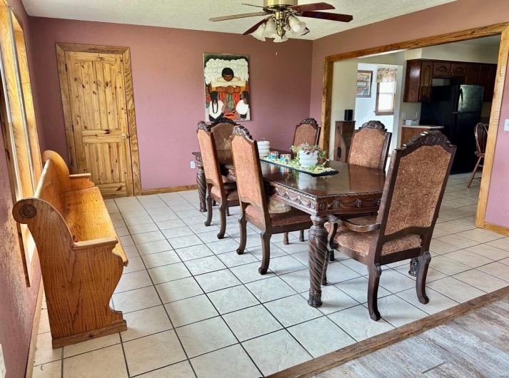 Dining room featuring light tile patterned floors, a textured ceiling, and ceiling fan