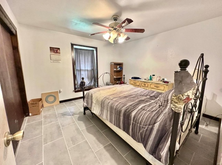 Bedroom featuring light tile patterned floors and ceiling fan
