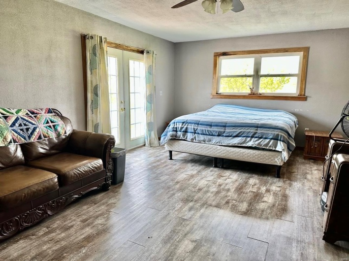 Bedroom featuring access to outside, a textured ceiling, a ceiling fan, and wood finished floors