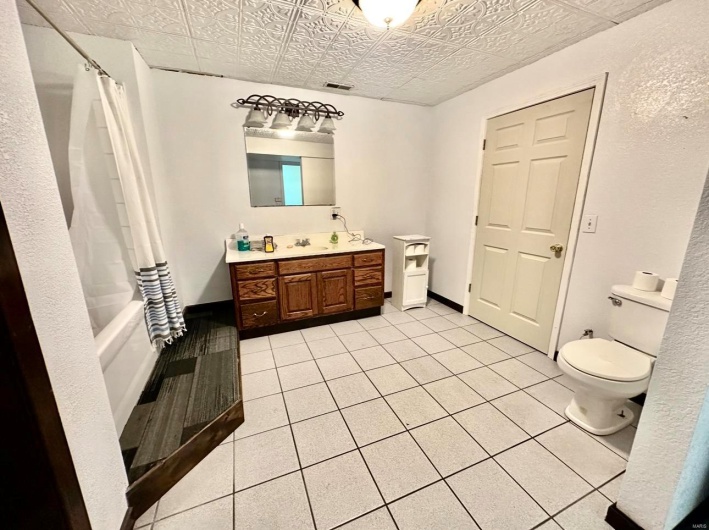 Full bathroom featuring visible vents, toilet, vanity, an ornate ceiling, and tile patterned flooring