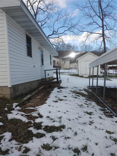View of snowy exterior featuring a storage shed