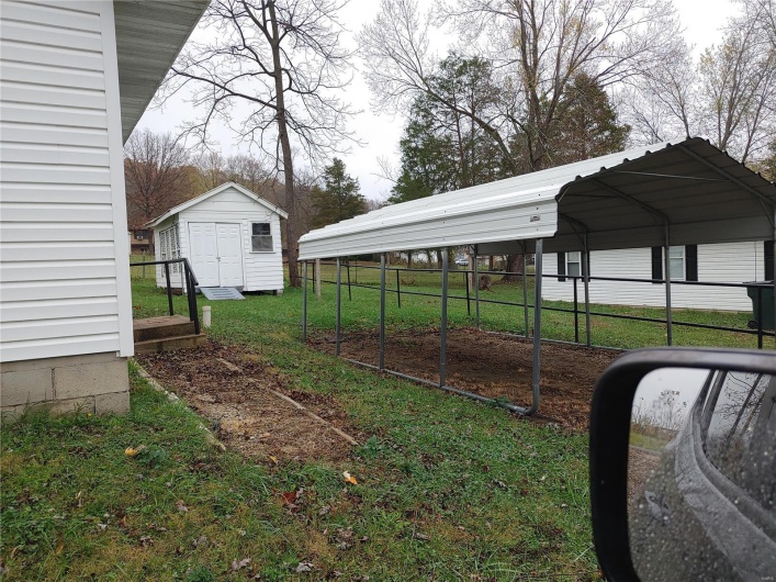 View of yard with a carport and a storage shed