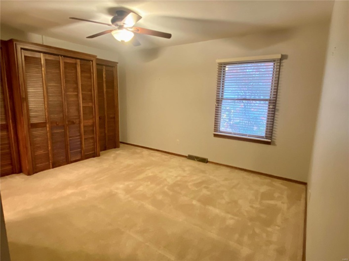 Unfurnished bedroom with carpet and ceiling fan