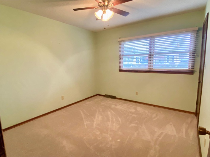 Empty room featuring light carpet and ceiling fan