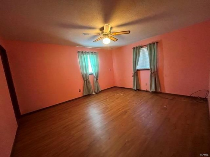 Spare room featuring wood finished floors and ceiling fan