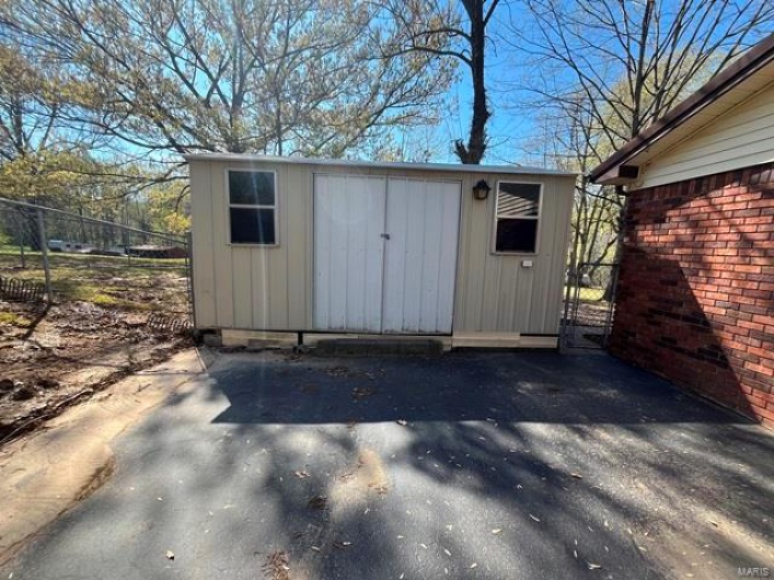 View of shed featuring fence