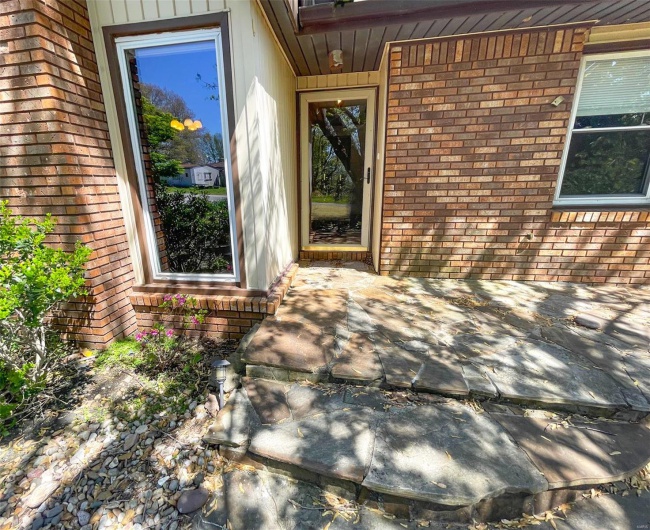 Entrance to property featuring brick siding