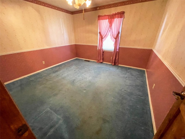 Empty room with visible vents, baseboards, and carpet