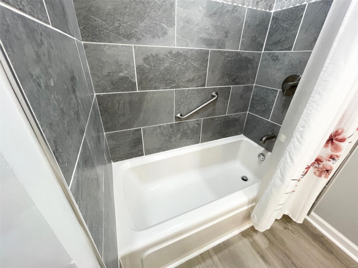 Bathroom with shower / tub combo and wood finished floors
