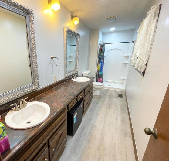 Full bathroom featuring a shower with shower curtain, a sink, toilet, and wood finished floors