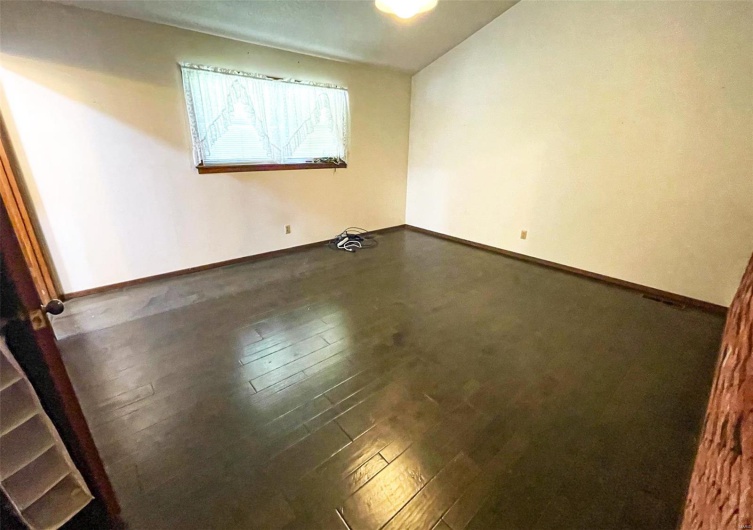 Empty room featuring wood-type flooring and baseboards