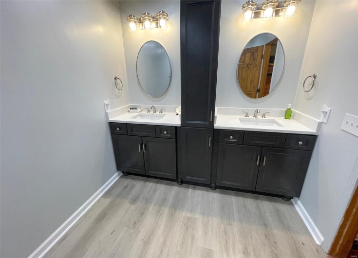Full bathroom featuring wood finished floors, vanity, and baseboards