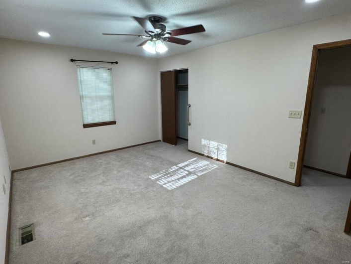 Spare room with visible vents, baseboards, a ceiling fan, and carpet flooring