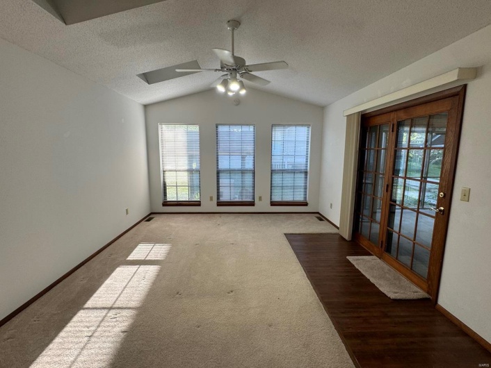 Empty room with baseboards, a ceiling fan, lofted ceiling, and carpet floors