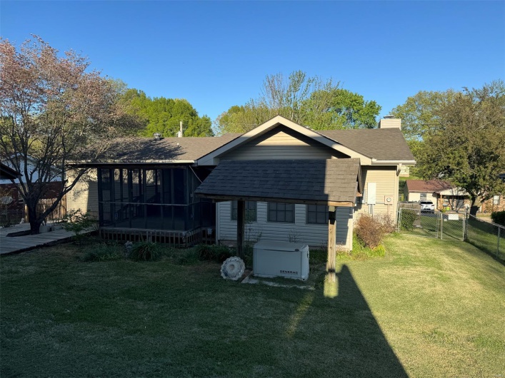 Rear view of house with a sunroom, a yard, a chimney, a gate, and roof with shingles