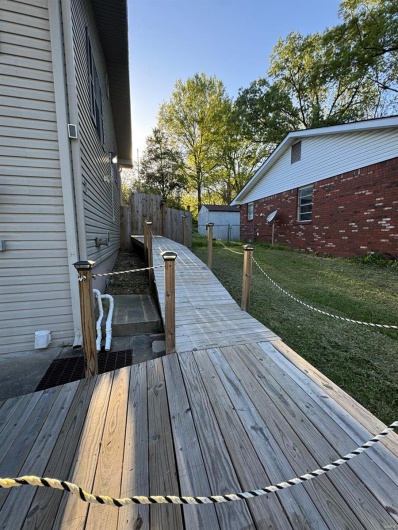 Wooden deck featuring a yard and fence