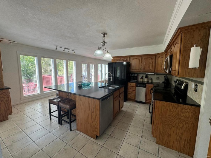 Kitchen with stainless steel appliances, plenty of natural light, a sink, and dark countertops