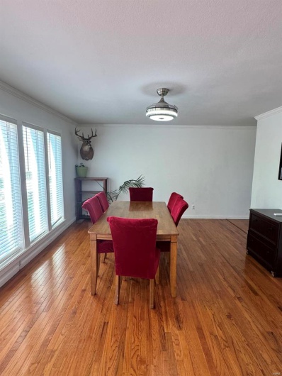 Dining room featuring crown molding, light wood-style flooring, and a textured ceiling