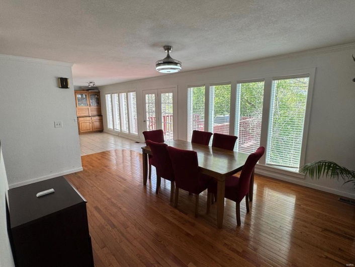 Dining room with a textured ceiling, crown molding, and a wealth of natural light
