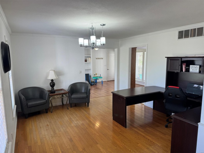 Office featuring crown molding, light wood-type flooring, and a chandelier