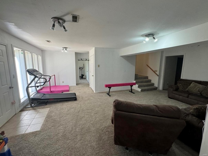 Rec room with visible vents, carpet flooring, and tile patterned flooring