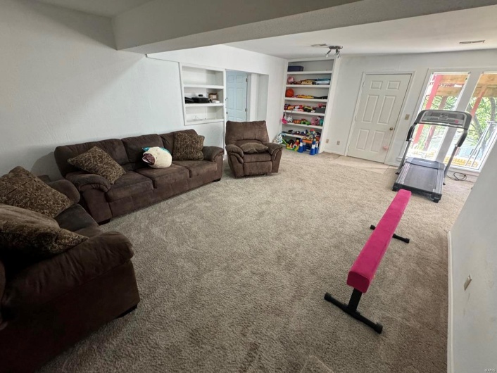 Living room with carpet and built in shelves