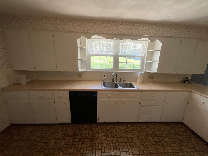 Kitchen featuring white cabinetry, dishwasher, a sink, and open shelves