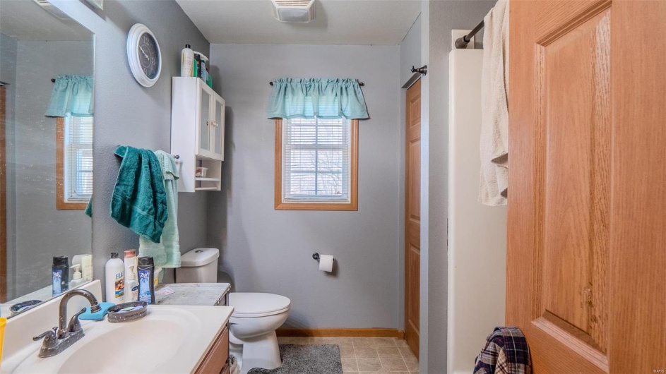 Bathroom featuring vanity, visible vents, baseboards, walk in shower, and toilet