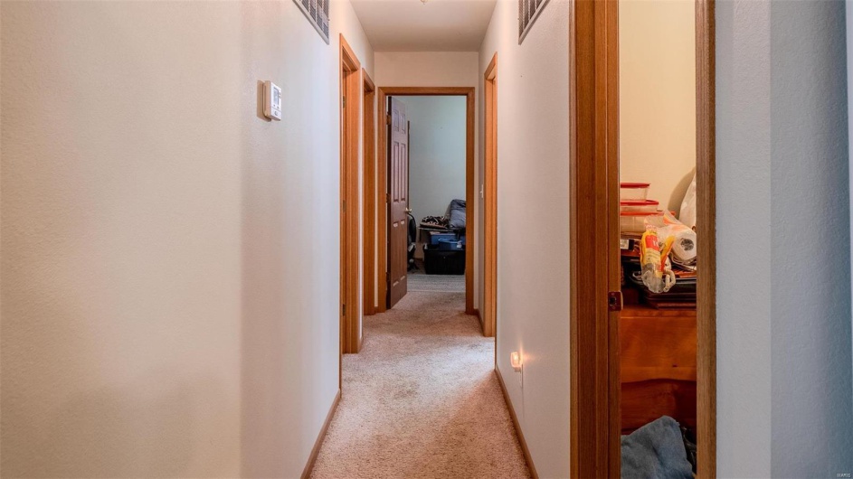 Hallway featuring light carpet and visible vents