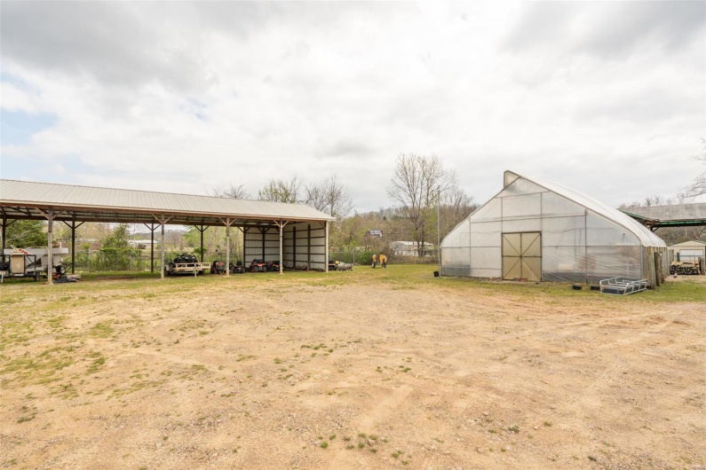 View of yard featuring a detached carport and an outbuilding
