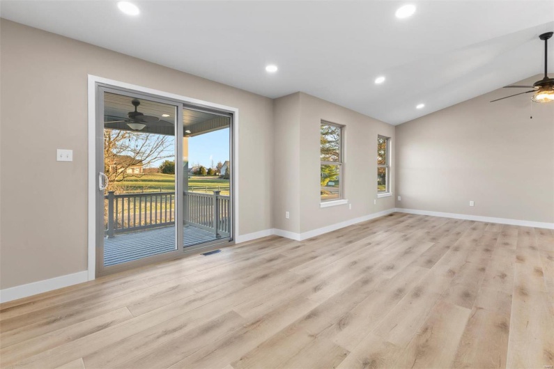 Spare room with light wood-type flooring, vaulted ceiling, and ceiling fan