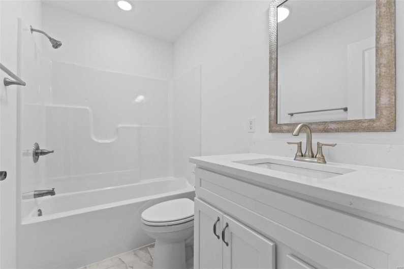 Full bathroom featuring washtub / shower combination, vanity, and toilet