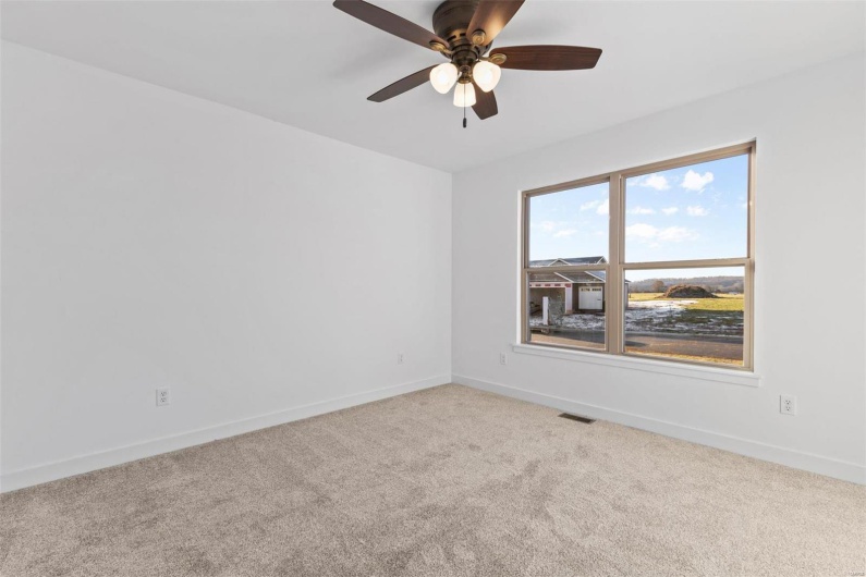 Carpeted spare room with ceiling fan