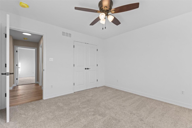 Unfurnished bedroom featuring ceiling fan, light carpet, and a closet