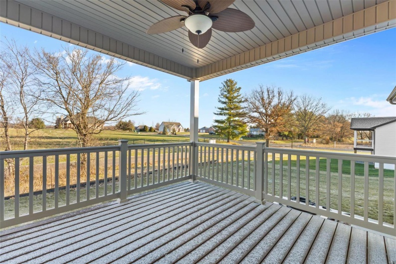 Wooden terrace featuring a yard and ceiling fan