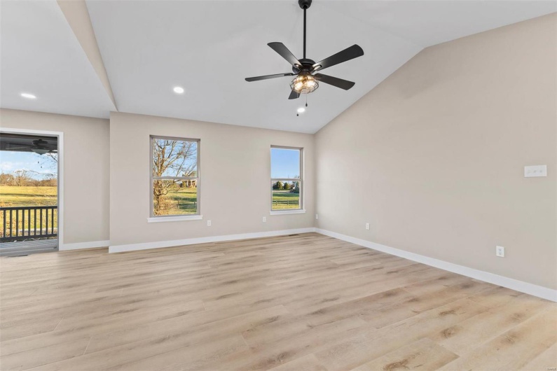 Spare room featuring ceiling fan, light hardwood / wood-style floors, and lofted ceiling