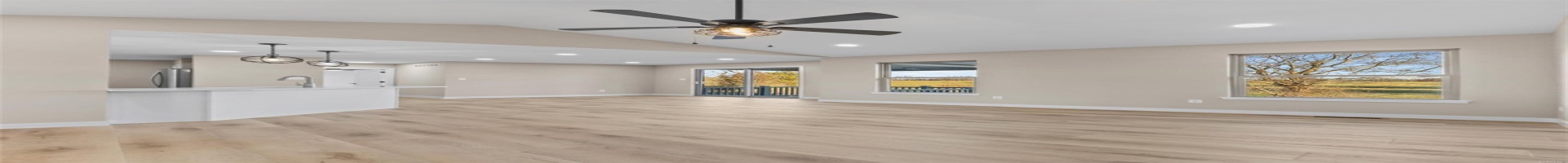 Residential For Sale Unfurnished living room featuring ceiling fan with notable chandelier, light hardwood / wood-style floors, and vaulted ceiling