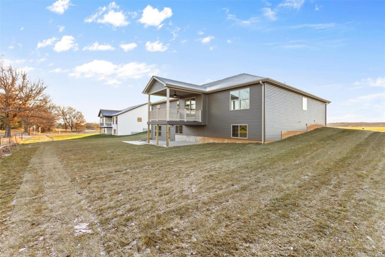 View of side of home with a lawn and a patio area