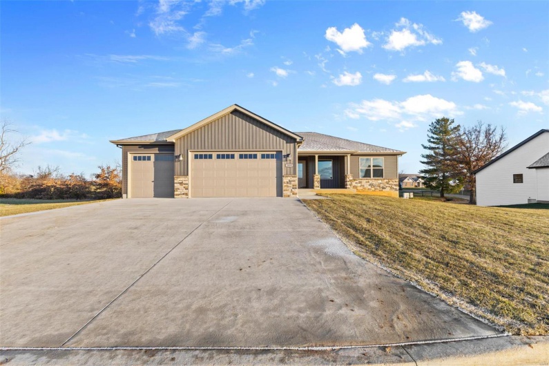 View of front of house featuring a garage and a front yard