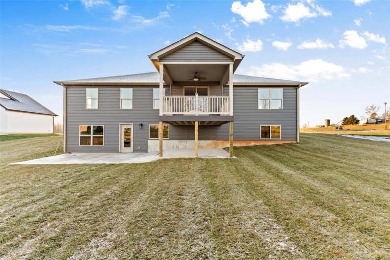 Rear view of property with a patio, ceiling fan, and a lawn