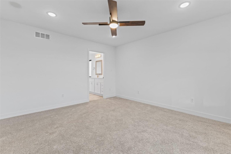 Spare room with light carpet and ceiling fan