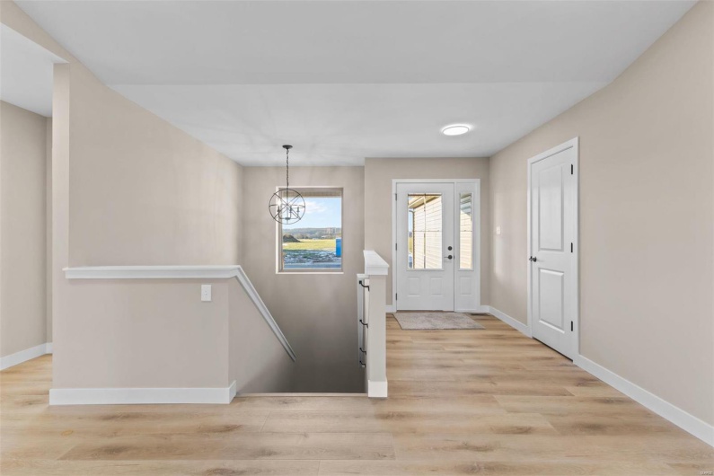 Foyer entrance featuring light wood-type flooring and a notable chandelier