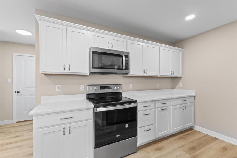 Kitchen featuring white cabinets, light wood-type flooring, and appliances with stainless steel finishes