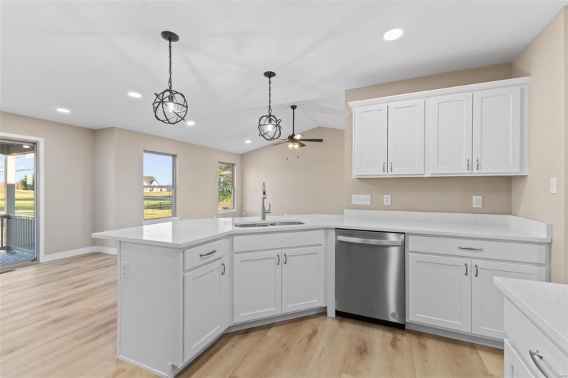Kitchen with stainless steel dishwasher, ceiling fan, a healthy amount of sunlight, and sink