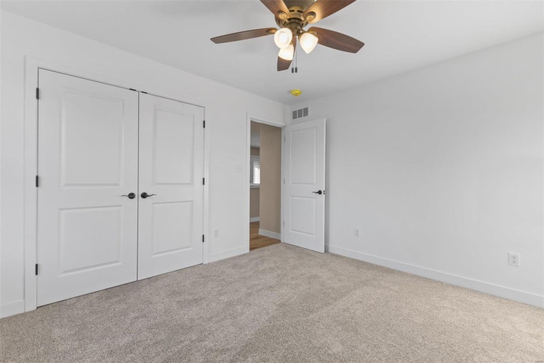Unfurnished bedroom with carpet, a closet, and ceiling fan