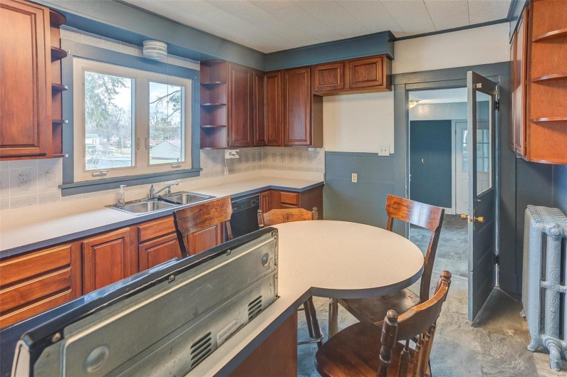 Kitchen featuring dishwasher, radiator, a sink, and open shelves