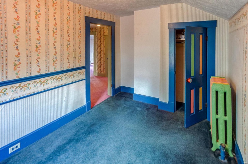Spare room with lofted ceiling, carpet flooring, and a textured ceiling