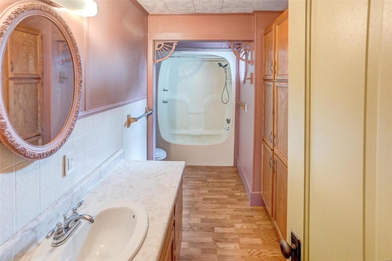 Bathroom featuring vanity, tile walls, a wainscoted wall, walk in shower, and wood finished floors